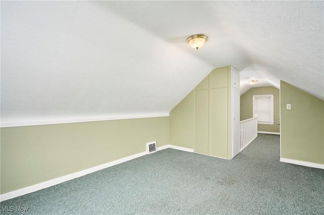 bonus room with vaulted ceiling, carpet flooring, and a textured ceiling