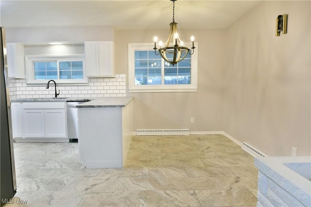 kitchen with sink, hanging light fixtures, dishwasher, white cabinets, and backsplash