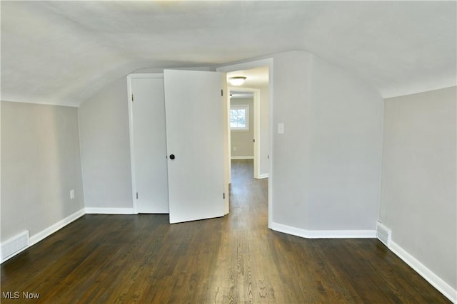 bonus room featuring vaulted ceiling and dark wood-type flooring