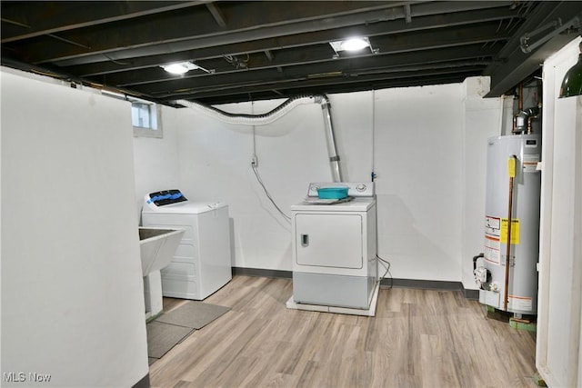 washroom with gas water heater, wood-type flooring, and washing machine and clothes dryer