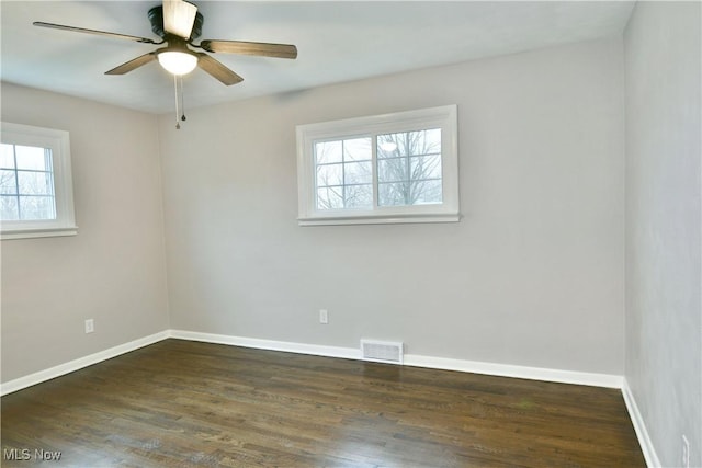 spare room featuring dark wood-type flooring and ceiling fan