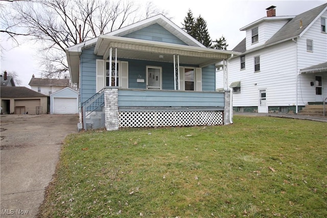 bungalow with a garage, an outbuilding, and a front yard