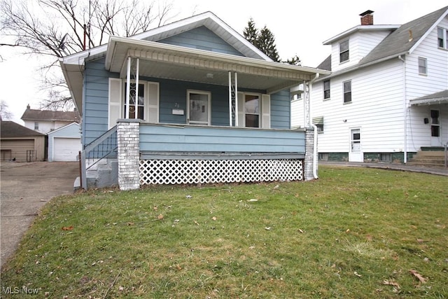 bungalow-style house featuring an outbuilding, a garage, a front lawn, and covered porch