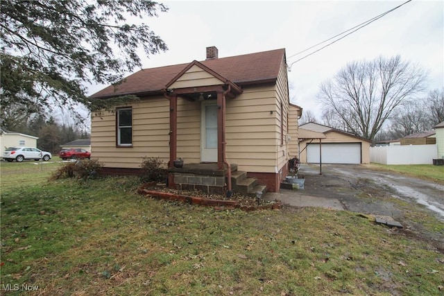 bungalow-style house with a garage and a front lawn