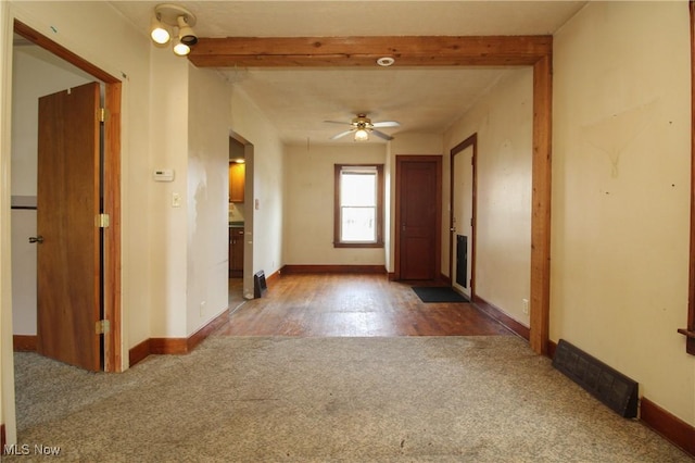 hallway with beamed ceiling and carpet flooring