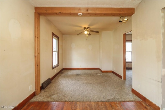 unfurnished room featuring beamed ceiling, ceiling fan, and wood-type flooring