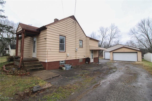 view of home's exterior featuring a garage and an outbuilding