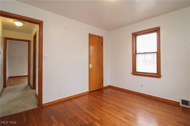 spare room with hardwood / wood-style floors