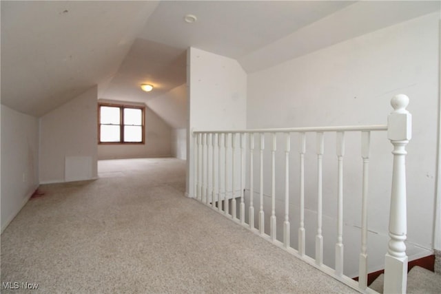 additional living space featuring lofted ceiling and light carpet