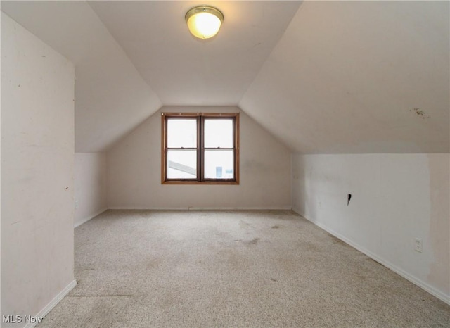 bonus room featuring lofted ceiling and light carpet