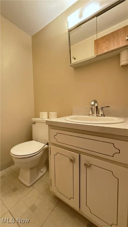 5540 Wrens Ln Unit 26D, Willoughby, OH 44094 - half bath featuring toilet, vanity, tile patterned floors, and a textured ceiling