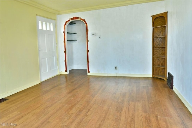 empty room with crown molding and hardwood / wood-style floors