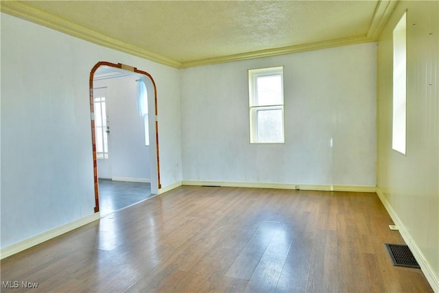 unfurnished room with crown molding, hardwood / wood-style floors, and a textured ceiling