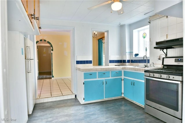 kitchen with dark hardwood / wood-style flooring, sink, blue cabinetry, and gas stove