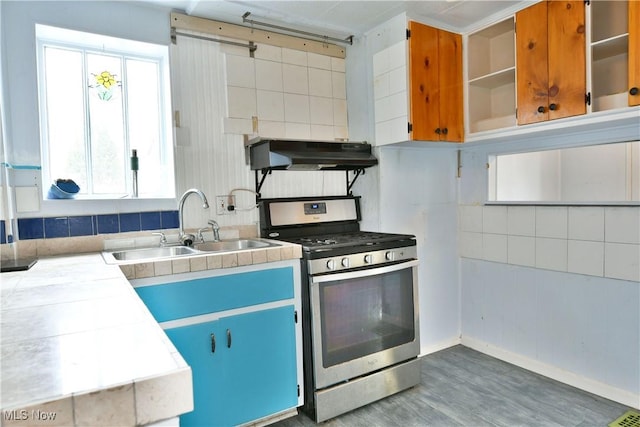 kitchen with sink, dark hardwood / wood-style floors, tile countertops, and stainless steel range with gas stovetop