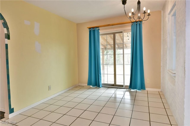 empty room featuring light tile patterned flooring and a notable chandelier