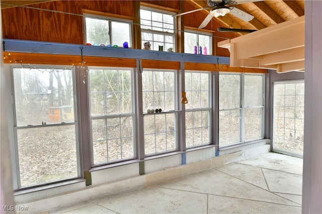 unfurnished sunroom featuring ceiling fan and a healthy amount of sunlight