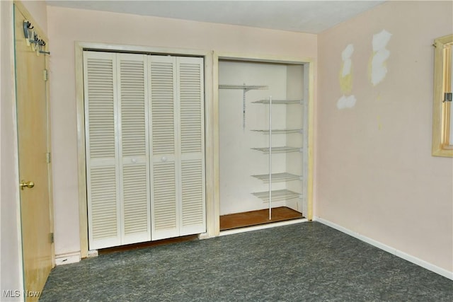 unfurnished bedroom with multiple closets and dark colored carpet