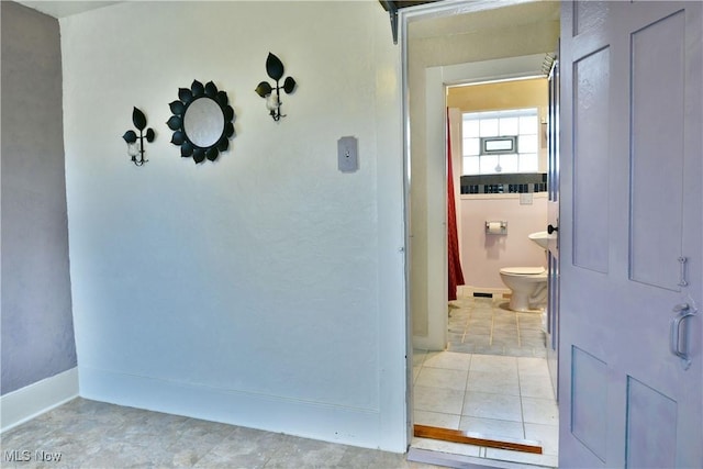 bathroom with toilet and tile patterned flooring