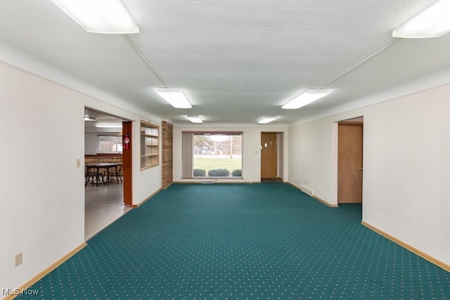 carpeted spare room featuring a textured ceiling