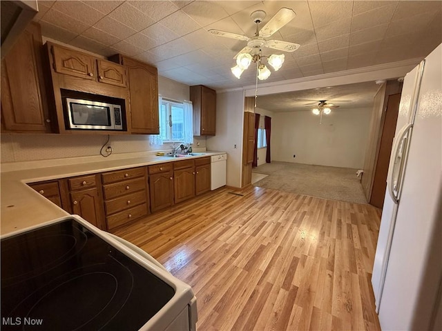 kitchen featuring ceiling fan, sink, white appliances, and light hardwood / wood-style flooring