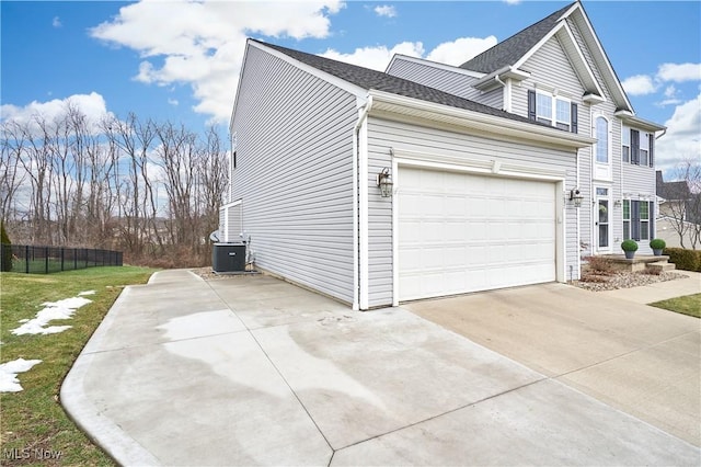 view of side of property with cooling unit and a garage