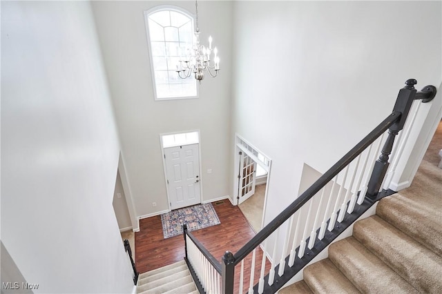 entrance foyer featuring an inviting chandelier, hardwood / wood-style flooring, and a high ceiling