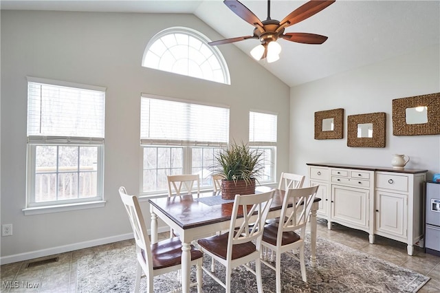 tiled dining area featuring vaulted ceiling, a healthy amount of sunlight, and ceiling fan