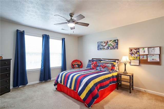 carpeted bedroom featuring ceiling fan and a textured ceiling