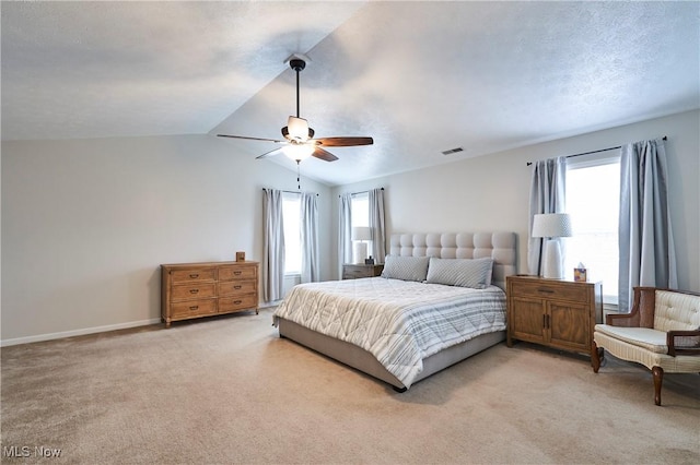 carpeted bedroom with multiple windows, lofted ceiling, a textured ceiling, and ceiling fan