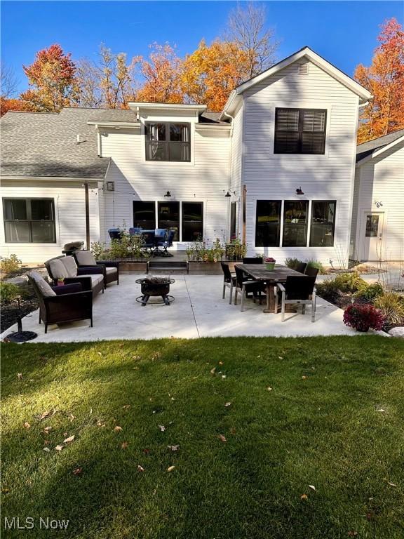 rear view of property with an outdoor living space, a patio, and a yard