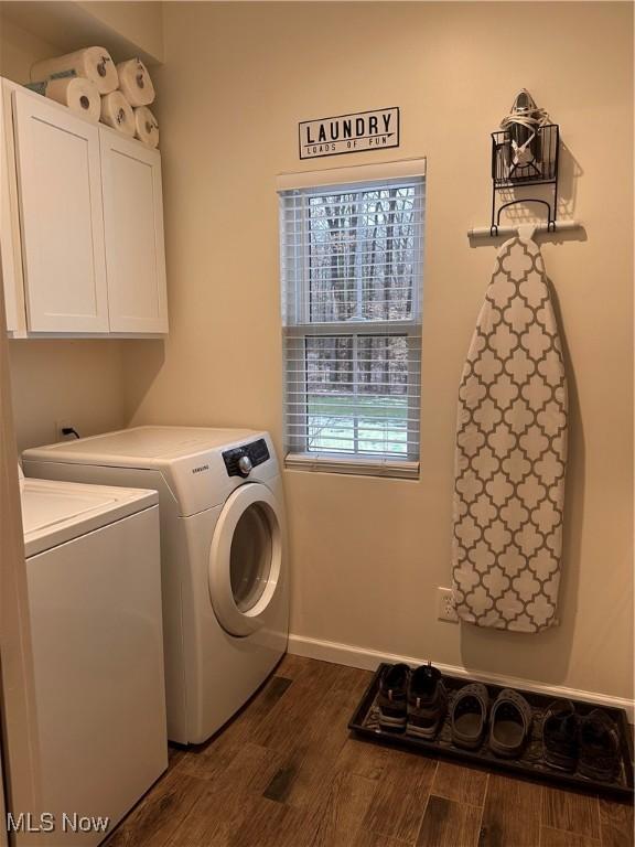 laundry area featuring cabinets, independent washer and dryer, and dark hardwood / wood-style flooring