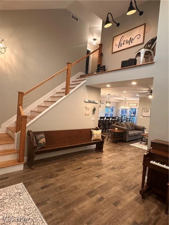 interior space with ceiling fan, hardwood / wood-style floors, and high vaulted ceiling