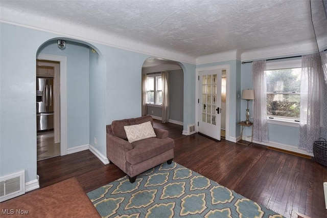 living area with dark hardwood / wood-style flooring and a textured ceiling