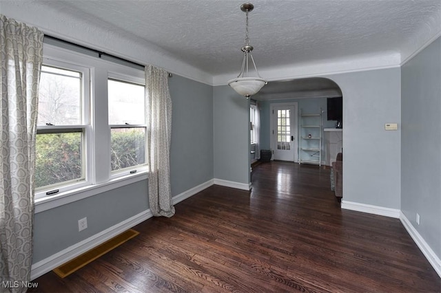 unfurnished dining area with a textured ceiling and dark hardwood / wood-style flooring