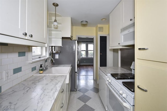 kitchen with pendant lighting, white appliances, light stone counters, white cabinets, and decorative backsplash