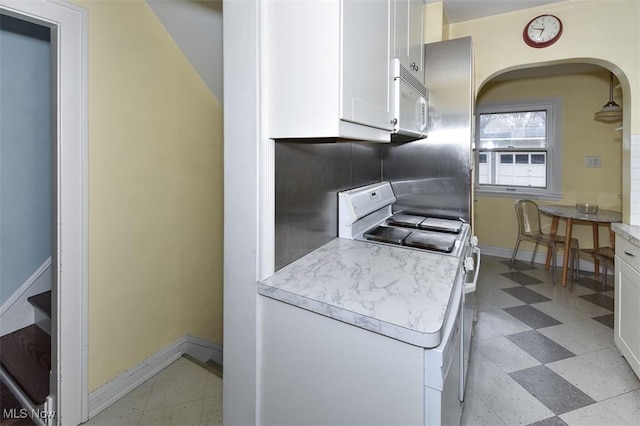 kitchen with white appliances, decorative backsplash, and white cabinets