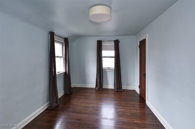 spare room featuring a wealth of natural light and dark hardwood / wood-style floors