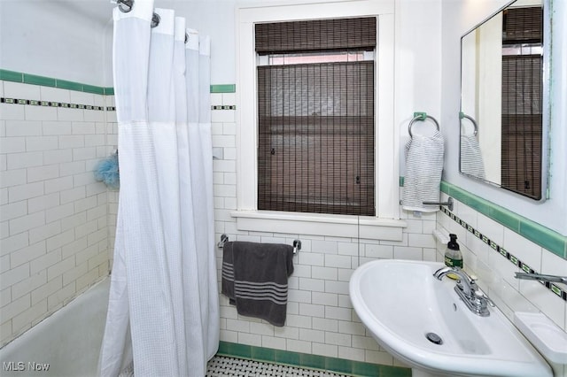 bathroom with shower / bath combination with curtain, sink, and tile walls