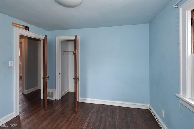 unfurnished bedroom with dark hardwood / wood-style floors