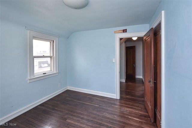 empty room with lofted ceiling and dark hardwood / wood-style floors