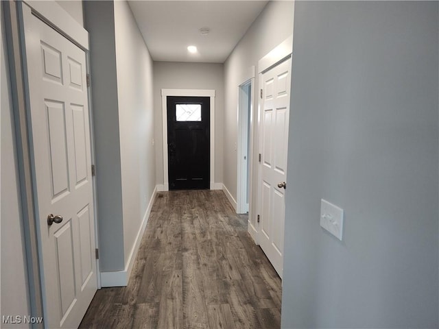 doorway featuring baseboards and dark wood finished floors