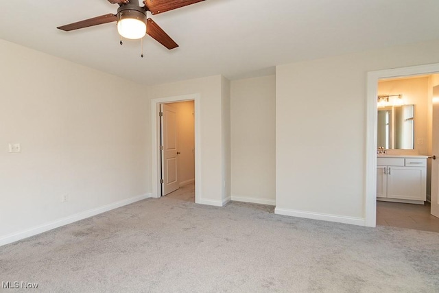 unfurnished bedroom with connected bathroom, sink, light carpet, and ceiling fan