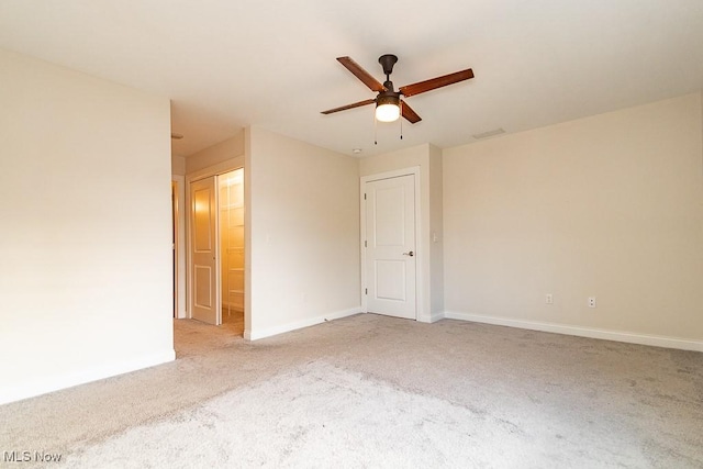 carpeted spare room featuring ceiling fan