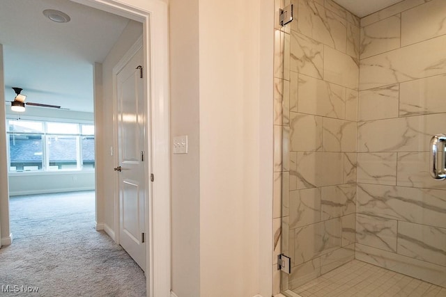 bathroom featuring ceiling fan and a shower with shower door