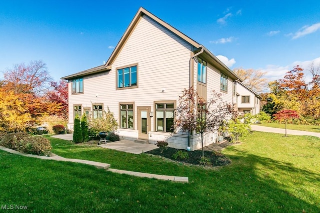 rear view of house featuring a yard and a patio area