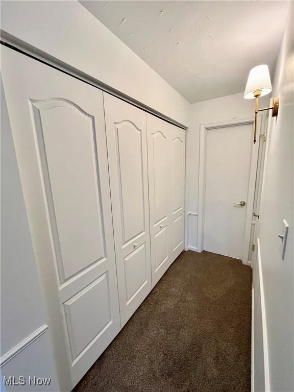 corridor with dark colored carpet