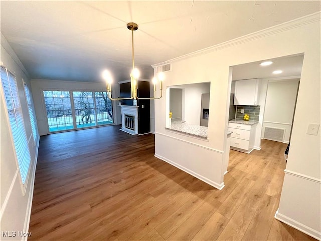 unfurnished living room with ornamental molding and light hardwood / wood-style flooring