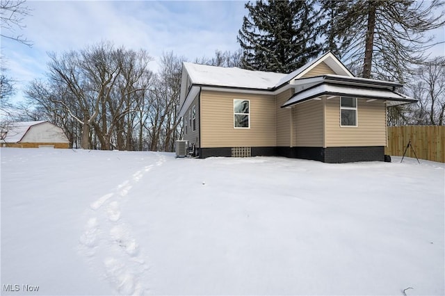 snow covered property with central AC unit