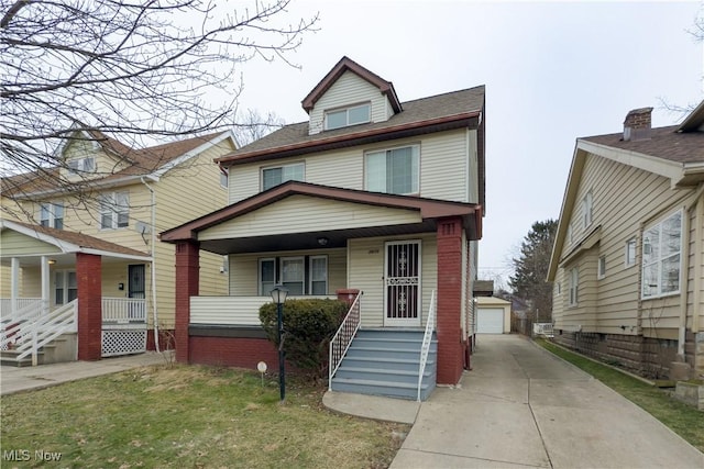 view of front of house featuring a garage, an outdoor structure, a front lawn, and a porch